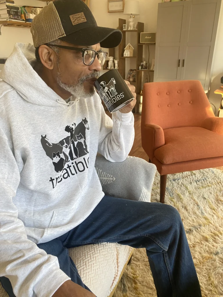 Alex with Treatibles coffee cup and hoodie